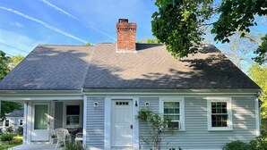 A single-story house with a front porch, a chimney, and a small garden area. - 3 Bedroom house, close to the beach and beech forest. (Eastham)
