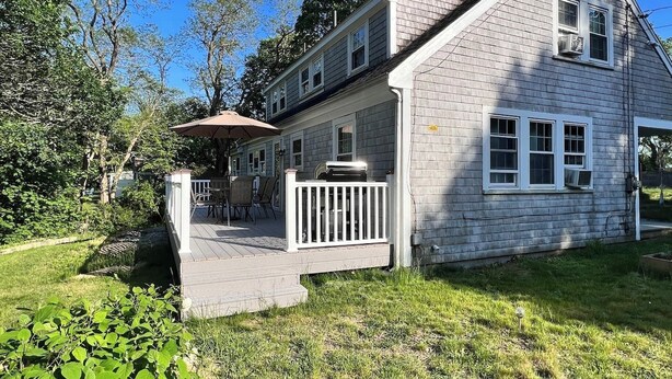 A two-story house with a deck, a satellite dish, and a large window. - 3 Bedroom house, close to the beach and beech forest. (Eastham)