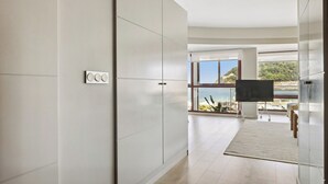Un interior moderno con un amplio ventanal, un televisor de pantalla plana y un diseño minimalista.