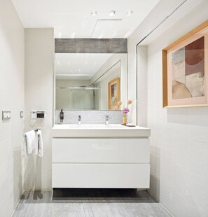 A modern bathroom with a large mirror, a white vanity, and a shower. - Playa de la Concha 9 by FeelFree Rentals (San Sebastián)