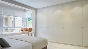 Un dormitorio con cama, escritorio y armario.