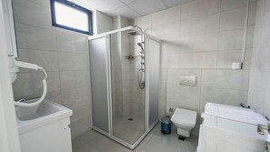 A modern bathroom with a glass-enclosed shower, a toilet, and a sink. - Cappadocia Ürgüp Apart Hotel (Ürgüp)