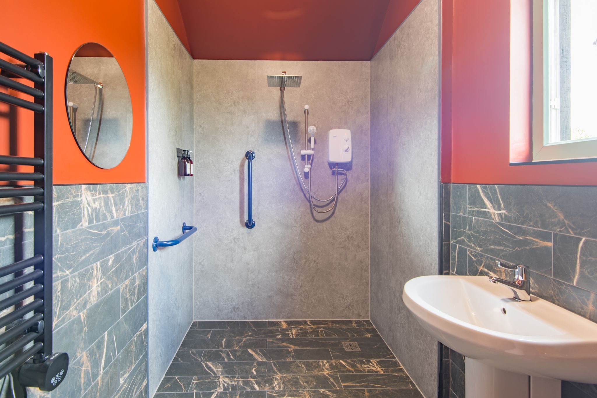 A modern bathroom with a shower, a sink, and a mirror.