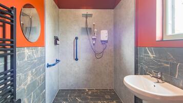 A modern bathroom with a shower, a sink, and a mirror.
