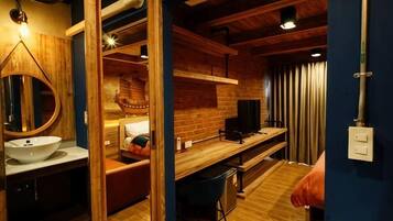 Un baño moderno con tocador de madera, un espejo grande y un lavamanos.