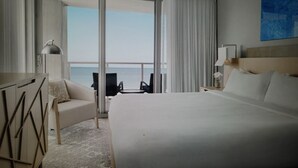 A hotel room with a large bed, a desk, a chair, and a view of the sea through the window. - Charming 3-bedroom Gulf-view villa with many amenities in amazing Marco Island (Marco Island)
