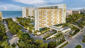 A modern hotel with multiple floors, a central courtyard, and a view of the ocean. - Charming 3-bedroom Gulf-view villa with many amenities in amazing Marco Island (Marco Island)