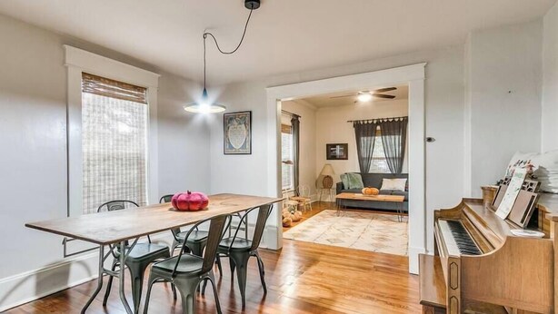 A spacious living area with a dining table, chairs, a sofa, a piano, and a ceiling fan. - Nestled Victorian Historic Area (Guthrie)