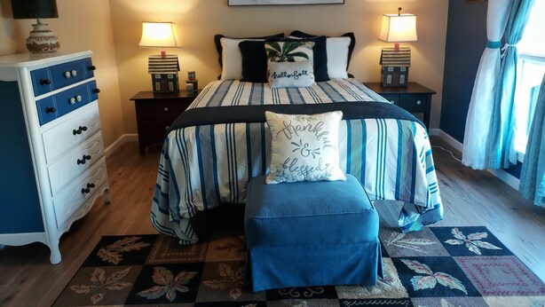 A bedroom with a bed, bedside tables, a dresser, a bench, a painting, and a window with curtains. - OLD DALLAS INN Charming 4-bedroom house, LARGE Dog friendly Backyard  (Elm Mott)