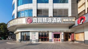 A hotel with a modern facade, large windows, and a prominent signage. - Changsha Xiaoyuan Selected Hotel (Changsha)