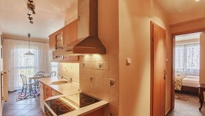 Una cocina moderna con estufa a gas, armarios de madera y salpicadero de azulejos.