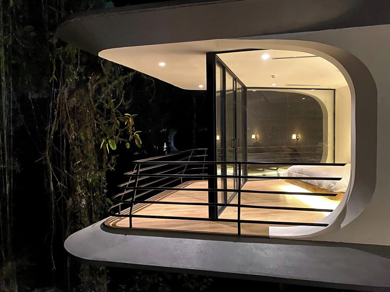 A modern, circular interior with a glass door leading to a bedroom.