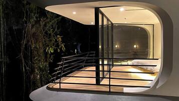 A modern, circular interior with a glass door leading to a bedroom.