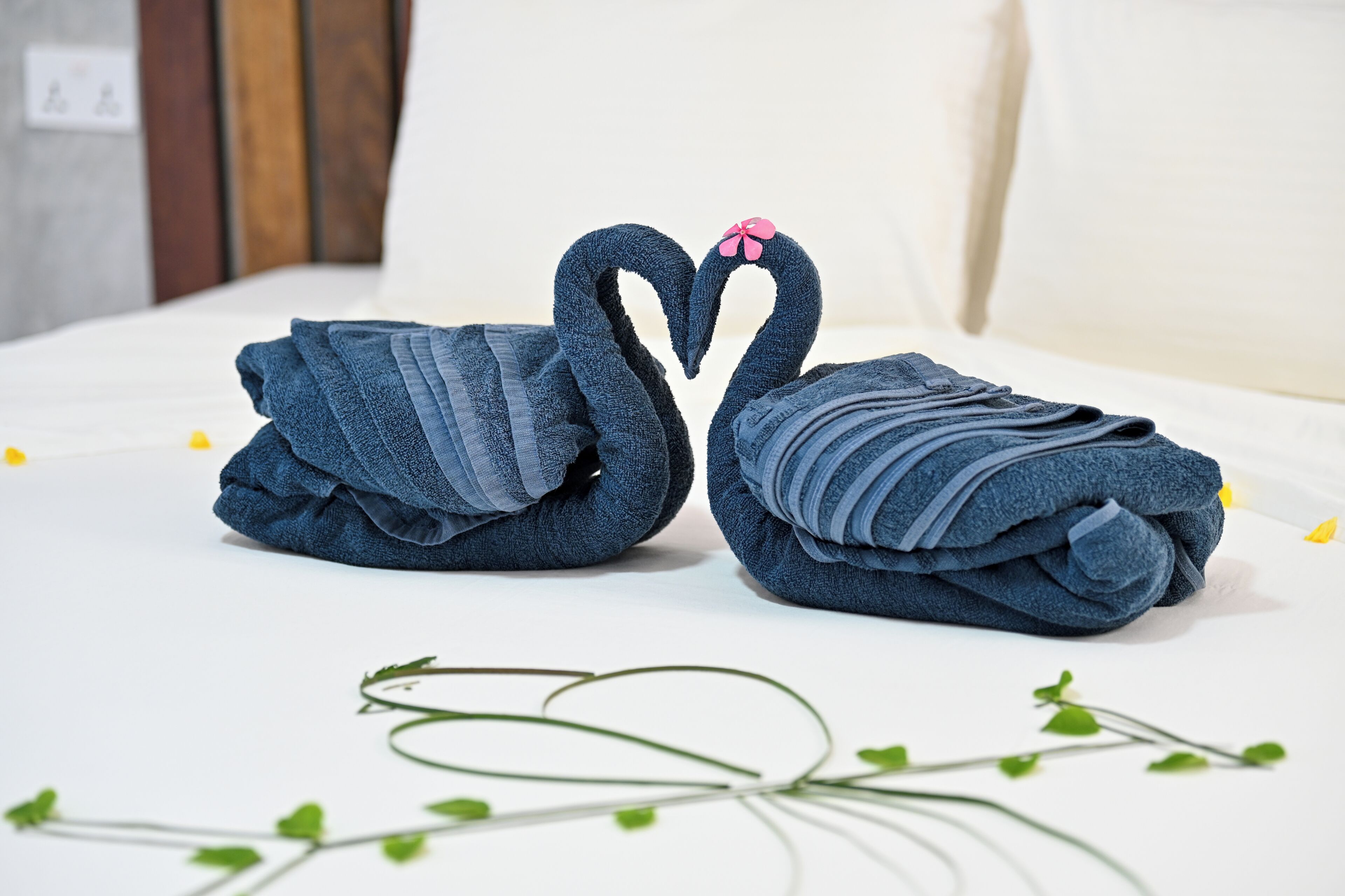 Una cama con toallas dispuestas en forma de cisnes.