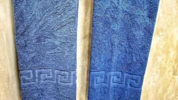 Two blue towels hanging on a rack with a white tissue box below.