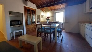 A compact living space with a dining area, a kitchen, and a built-in wardrobe.