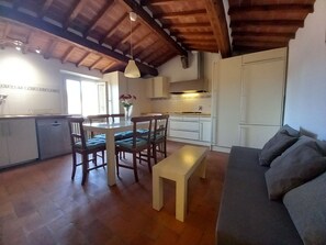 A compact living space with a dining area, kitchenette, and a sofa. - Porta Rossa in Firenze (Florence)
