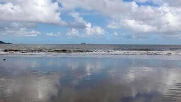 Une plage au sable humide et une mer calme.