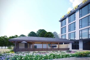 Un edificio moderno con un área de estar cubierta al aire libre y un jardín.