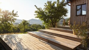 A wooden deck leading to a cabin with a view of mountains. - Thoreau Suite - A Large Studio With Mountain Views (Aramits / Pyrénées Atlantiques)