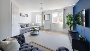 Ein Wohnzimmer mit grauem Sofa, einem schwarzen Couchtisch und einer blauen Akzentwand.