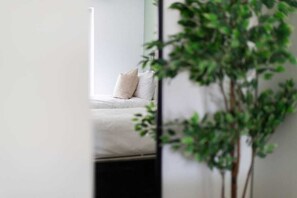 A room with a bed, a plant, and a white wall. - Stunning Home In Prime Location with Free Parking (Nottingham)