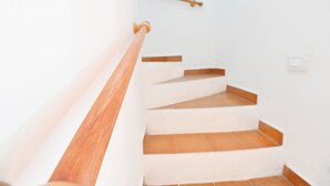 Un escalier avec des rampes en bois et des murs blancs.