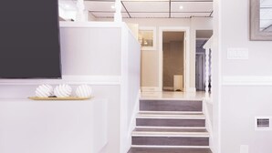 A staircase leading to a second floor, with a white wall and a door at the top.