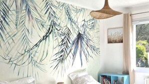A bedroom with two beds, a wall mural, a hanging light, and a window with curtains. - flat with two bedrooms, walking distance from the beach with parking and balcony (Perros-Guirec)