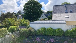 A residential area with a white car parked in a driveway, surrounded by lush greenery and flowering plants. - flat with two bedrooms, walking distance from the beach with parking and balcony (Perros-Guirec)