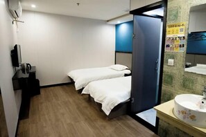A hotel room with two beds, a small desk with a kettle, a sink with a floral design, and a mirror above it. - Aishange Home Cinema Hotel (Zhuji Datang Branch) (Zhuji)