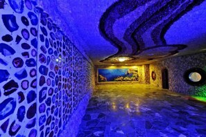 A room with a patterned wall, a mural, and a circular window. - Regao Hot Spring Hotel (Fushun)