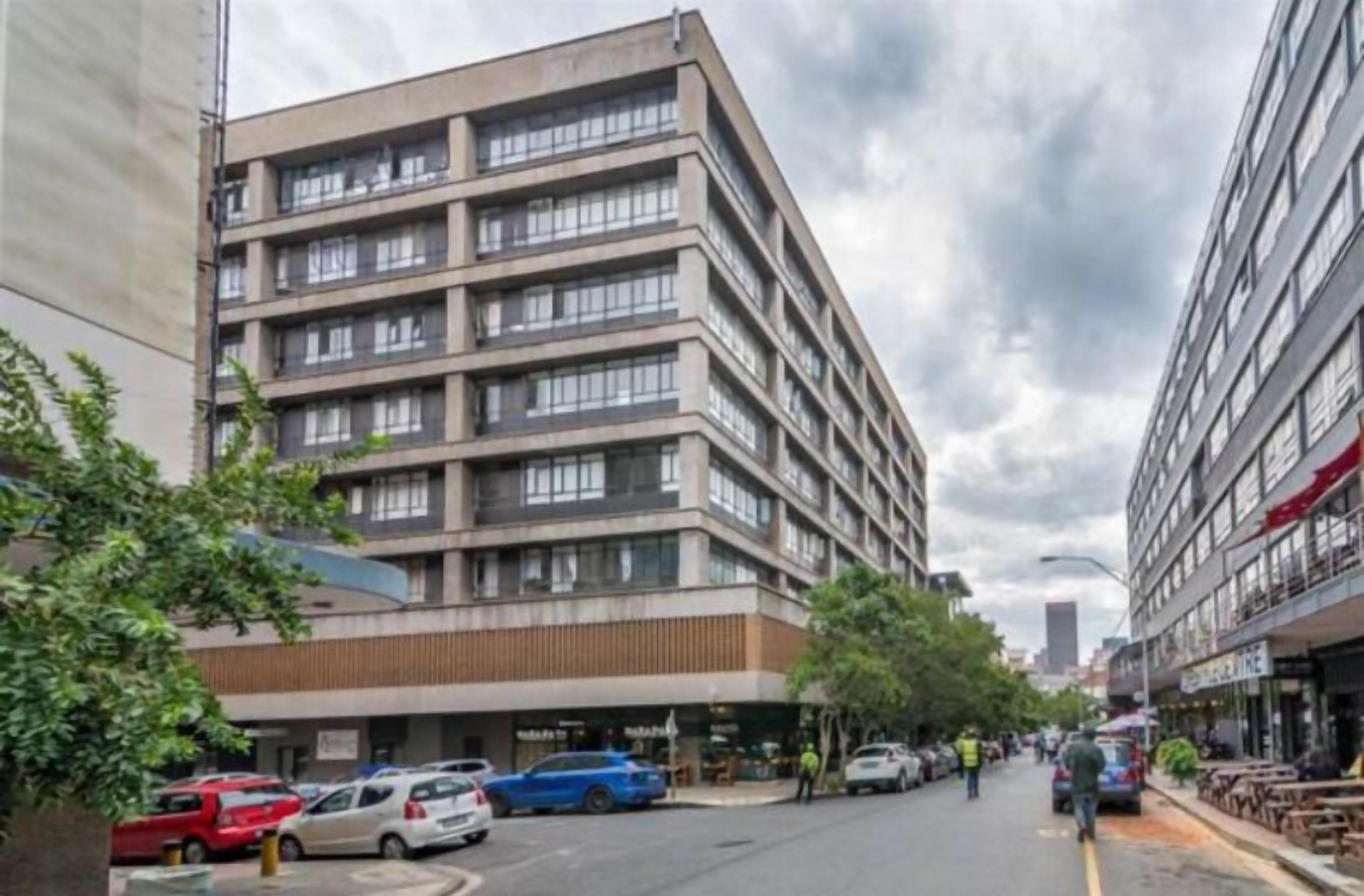A multi-story building with a modern architectural design, featuring a series of balconies and large windows.