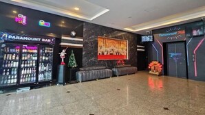 Ένας χώρος υποδοχής με ένα μπαρ της Paramount, έναν μεγάλο πίνακα σε κορνίζα στον τοίχο και μια περιοχή με καθίσματα, όπου βρίσκεται και ένα χριστουγεννιάτικο δέντρο.