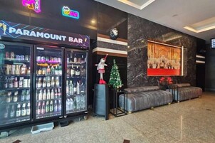 A lobby with a Paramount Bar, a Christmas tree, and a large painting on the wall.