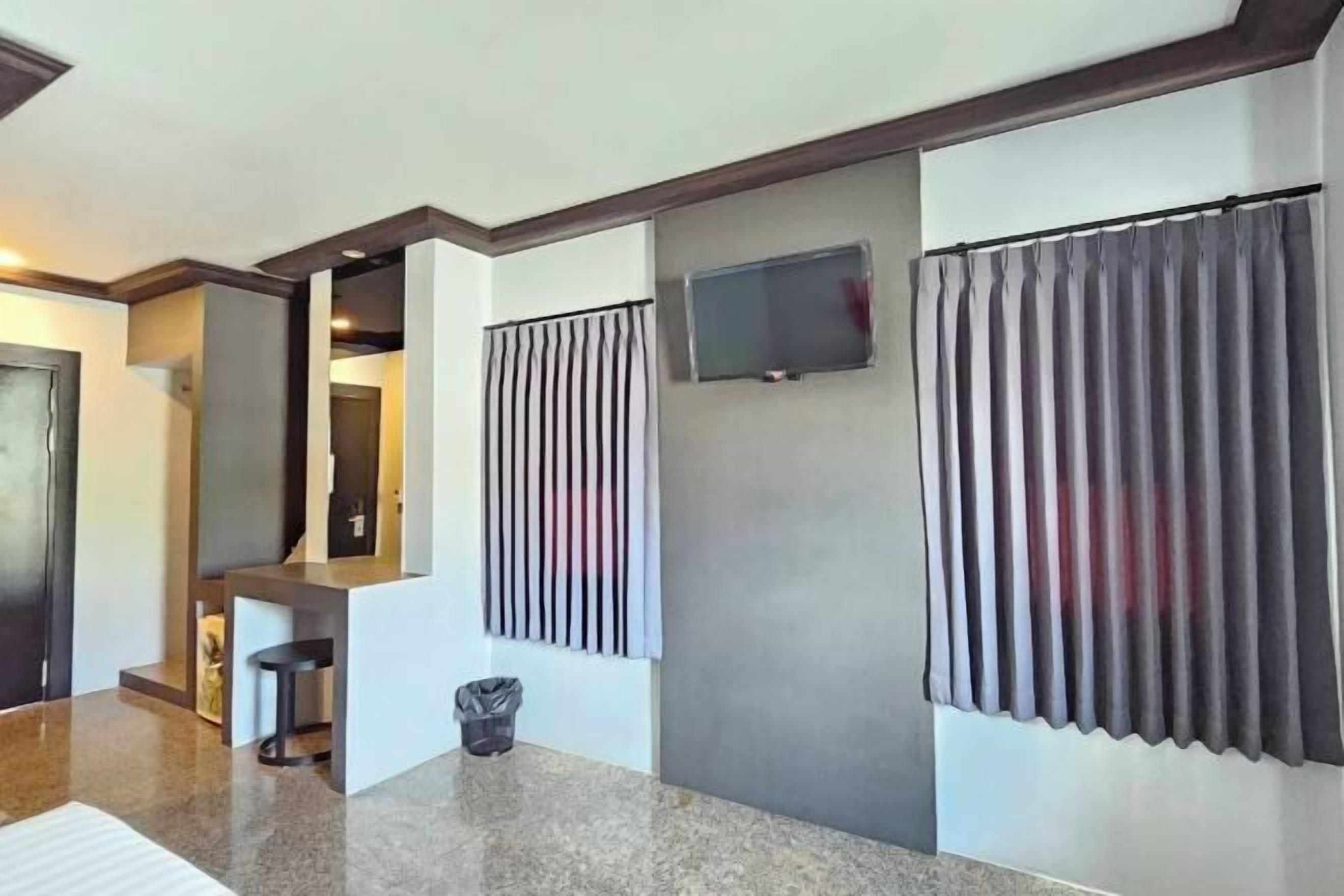 Un interior moderno con una zona de cocina, una barra y un televisor montado en la pared.