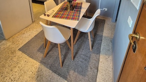 A dining area with a table, chairs, a TV, and a floral arrangement. - Appartamento al Centro di Roma Esquilino Colosseum Vicino Metro (Roma)