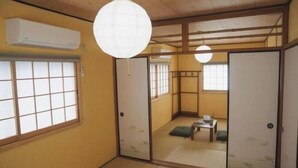 A traditional Japanese room with tatami flooring, sliding doors, and a ceiling fan. - Kokoro No Sato・Hitomi (Kyoto)