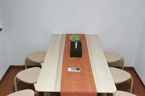 A conference table with a nameplate, a green placemat, and a black object on the table.