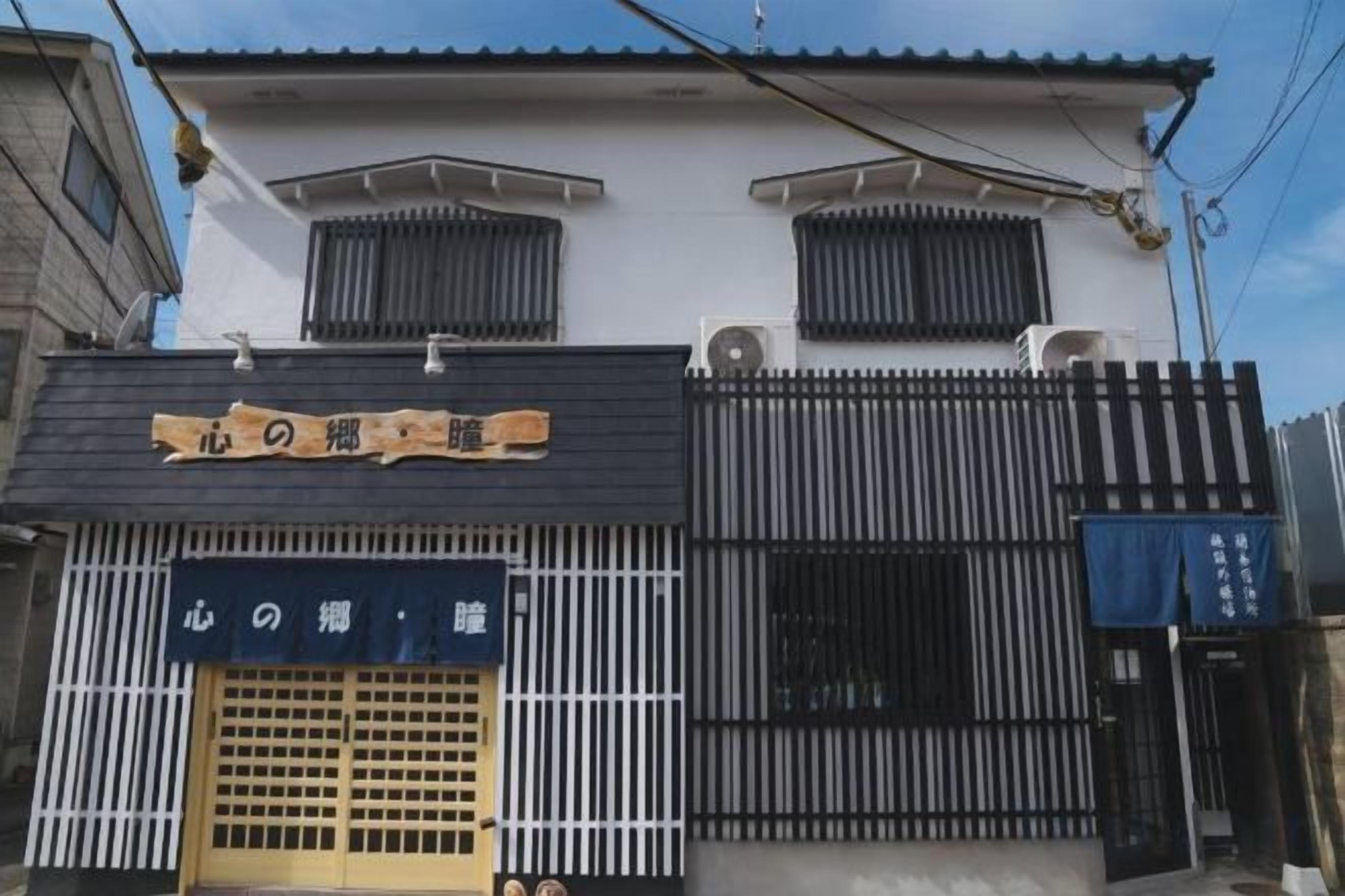 A building with a sign that reads '心の糸' and a blue awning with the same text.