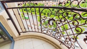A curved balcony with ornate metal railings and a view of parked cars and greenery below. - Lvtu Zhijia Apartment Hotel (Shanghai)