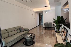 A modern living room with a sofa, coffee table, and chairs. - Lvtu Zhijia Apartment Hotel (Shanghai)