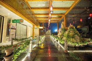 A corridor with a wooden ceiling, potted plants, and a sign indicating a restaurant. - Maigode Hotel (Henan People's Hall Yanzhuang Metro Station) (Zhengzhou)