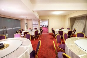 A conference room with round tables, chairs, and a red carpet. - Maigode Hotel (Henan People's Hall Yanzhuang Metro Station) (Zhengzhou)