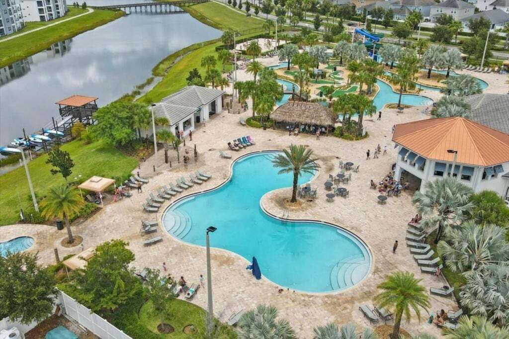 Un complexe hôtelier doté d’une grande piscine centrale, de plusieurs petites piscines et d’un quai au bord d’un lac.