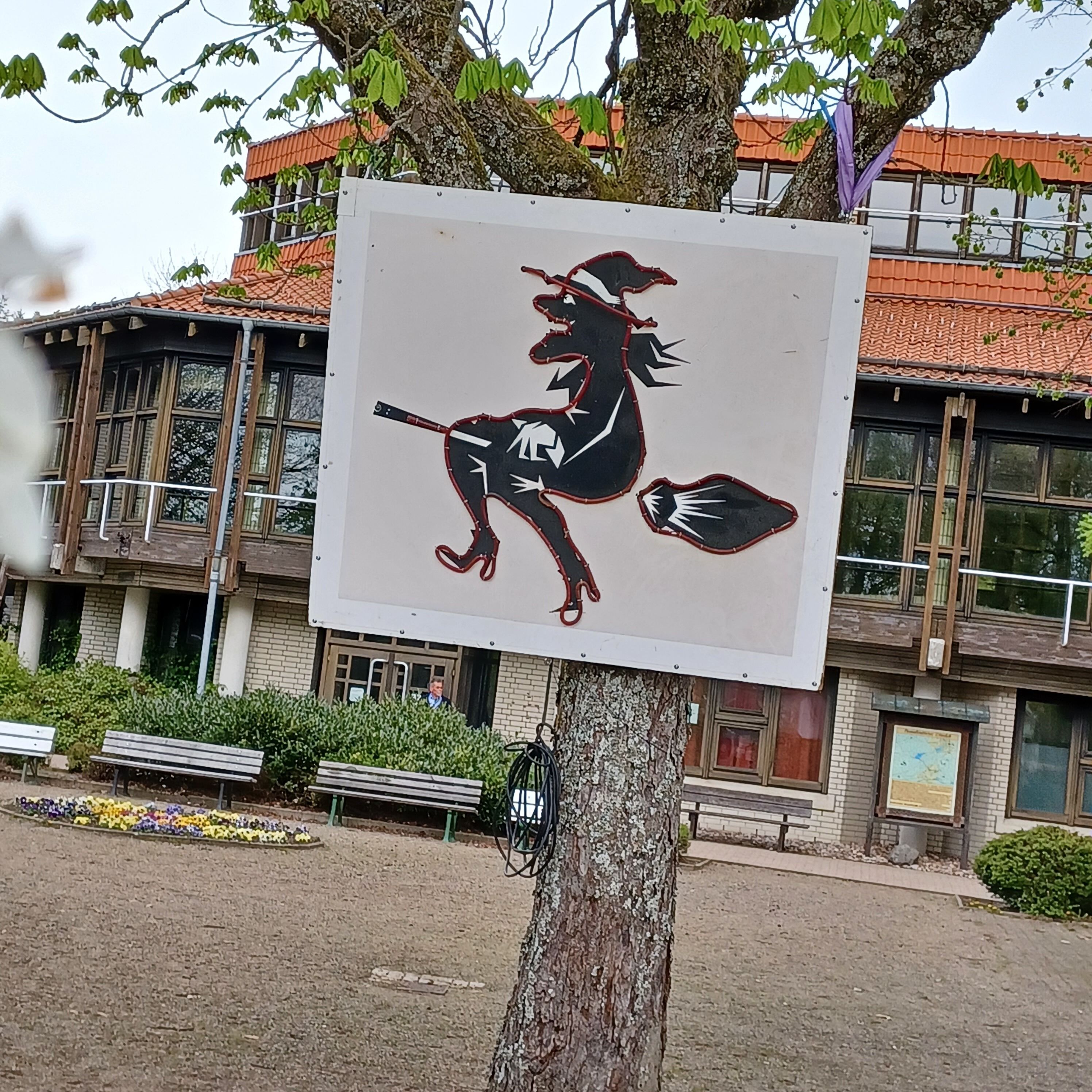 Une enseigne représentant une sorcière chevauchant un balai.
