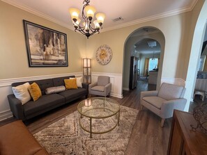 A living room with a sofa, armchairs, a coffee table, and a chandelier. - Lake Park 3BR • 9 Beds • Near I-75 • Groups (Lake Park)