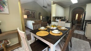 A dining area with a wooden table set for four, white chairs, and a kitchen in the background. - Lovely 3 bedroom, 2 Bath Home in Lake Park near I-75! (Lake Park)