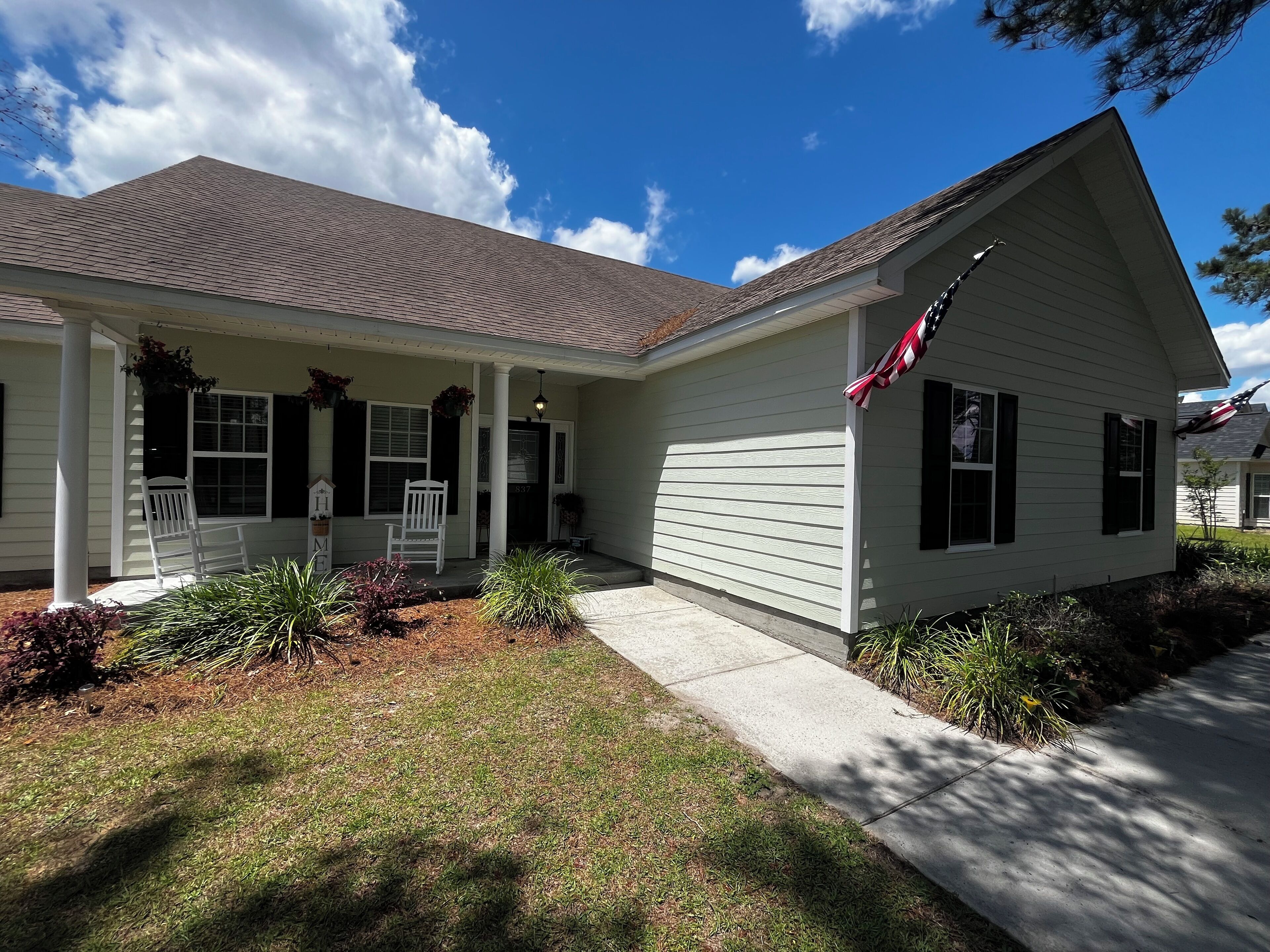 A single-story house with a front porch, a garage, and a small front yard.