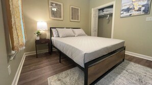 A bedroom with a bed, a nightstand, a lamp, a closet, and a painting on the wall. - Lovely 3 bedroom, 2 Bath Home in Lake Park near I-75! (Lake Park)